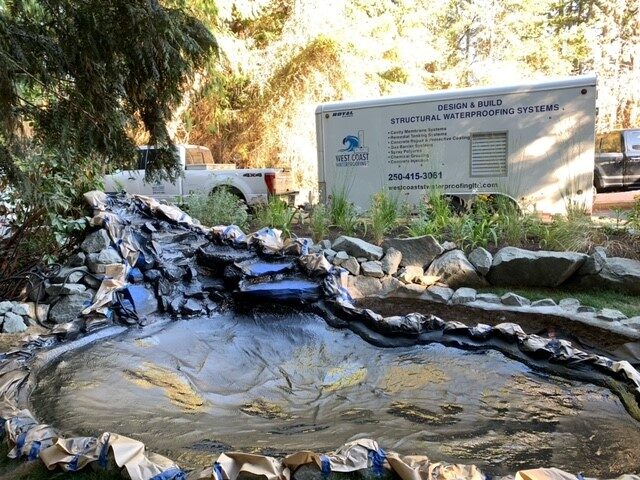 A leaking concrete garden pond before being relined by West Coast Waterproofing